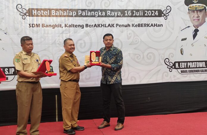 Kepala Dinas Tenaga Kerja dan Transmigrasi Prov Kalteng Farid Wajdi menyerahkan penghargaan Ke perwakilan PT AGL Muhammad Lucky Nugroho di Hotel Bahalap Palangka Raya, Selasa (16/7/2024).